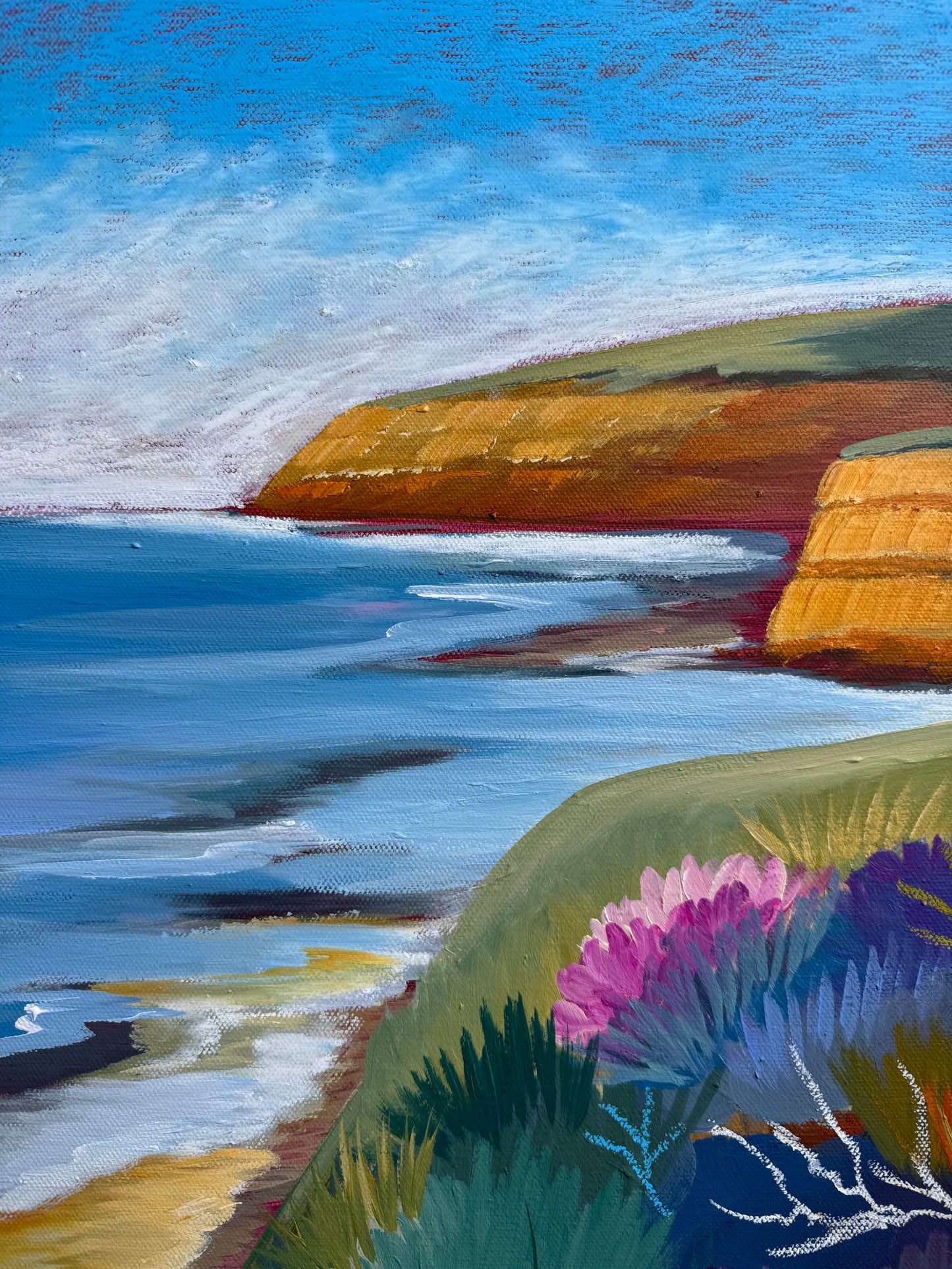 A close up of the colourful artwork Jan Juc at Day by Lauren Danger.  The image has vibrant colours of the cliffs sea and vegetation in Jan Juc in acrylic and pastel.