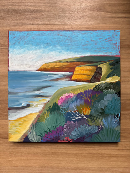 Jan Juc at Day by Lauren Danger, a colourful seascape original painting inspired by the Surf Coast location of Jan Juc near Torquay, Victoria, Australia. Painting is sitting on a wooden background for scale.