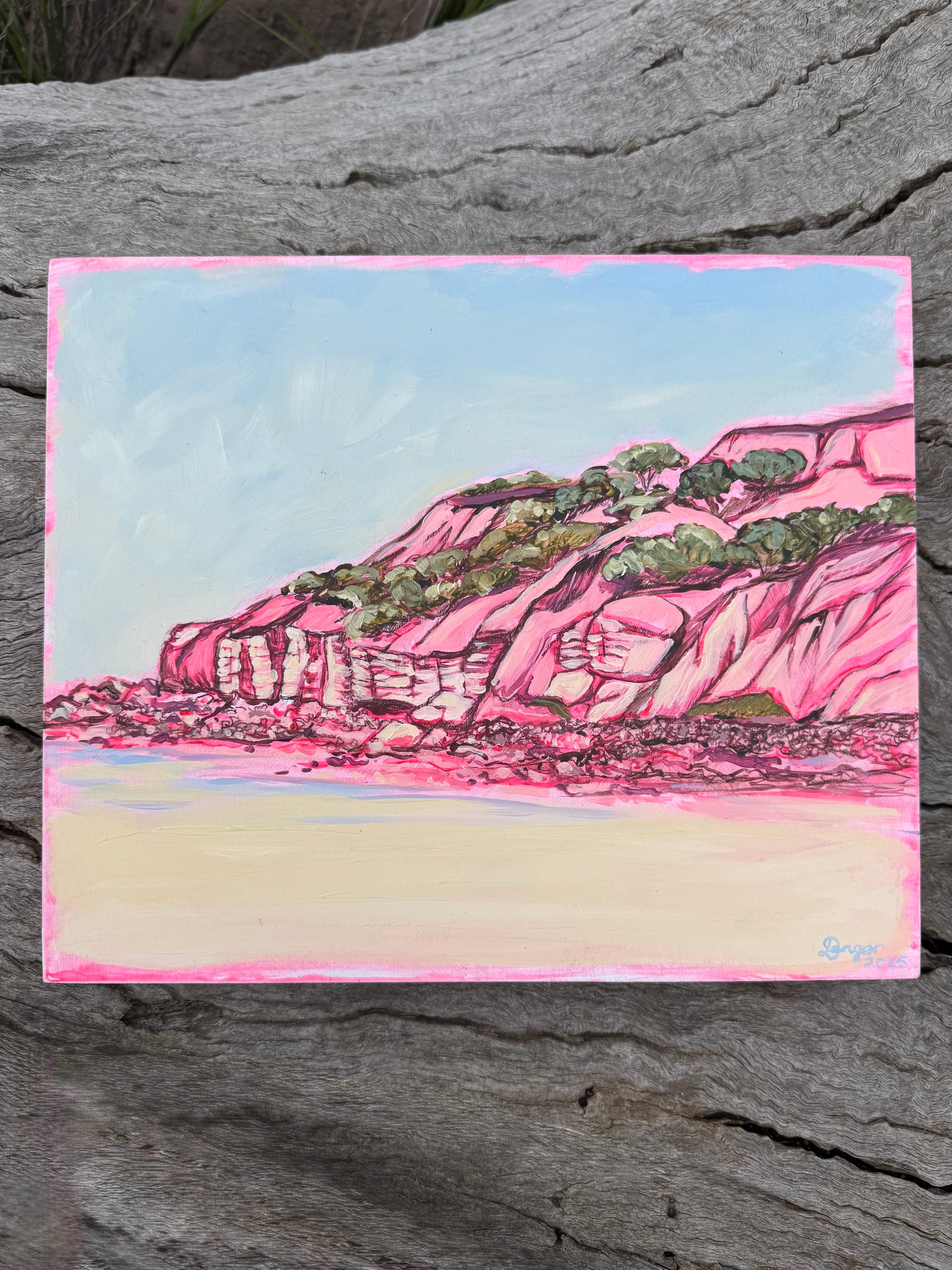 Point Addis in Pink artwork on board.  Sitting on a log in a bush setting.  Artwork inspired by Surf Coast, Great Ocean Road, Victoria, Australia.
